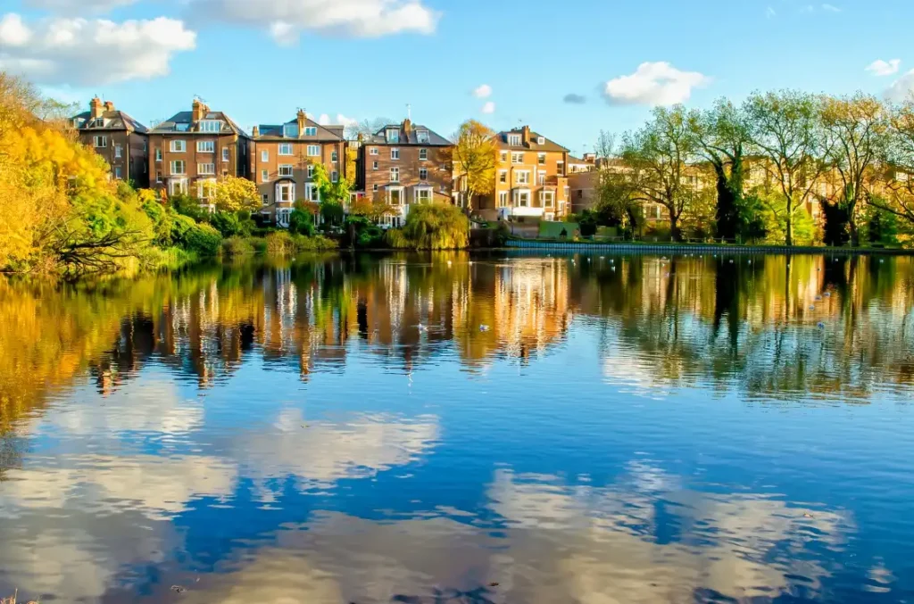 Reflections of houses in a pond at Hampstead Heath Park